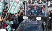 Candidate Lai, behind the protective glass on the left, during the election campaign. (© picture alliance / ASSOCIATED PRESS / Ichito Ohara)
